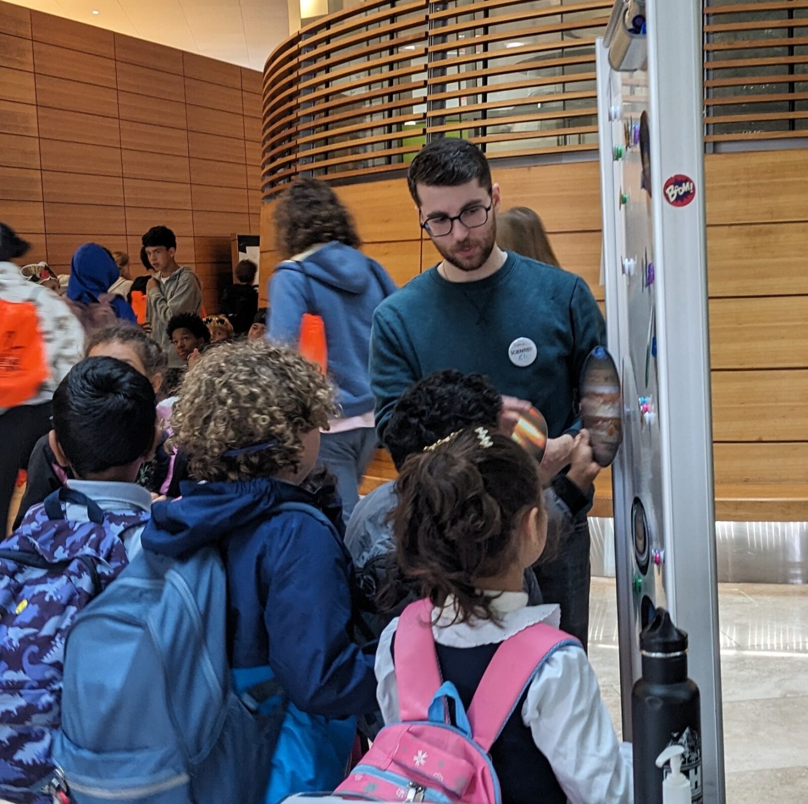 WiCOR graduate student presents the exoplanet activity to a group of curious elementary school attendees at the Discovery Expo in Oct 2025